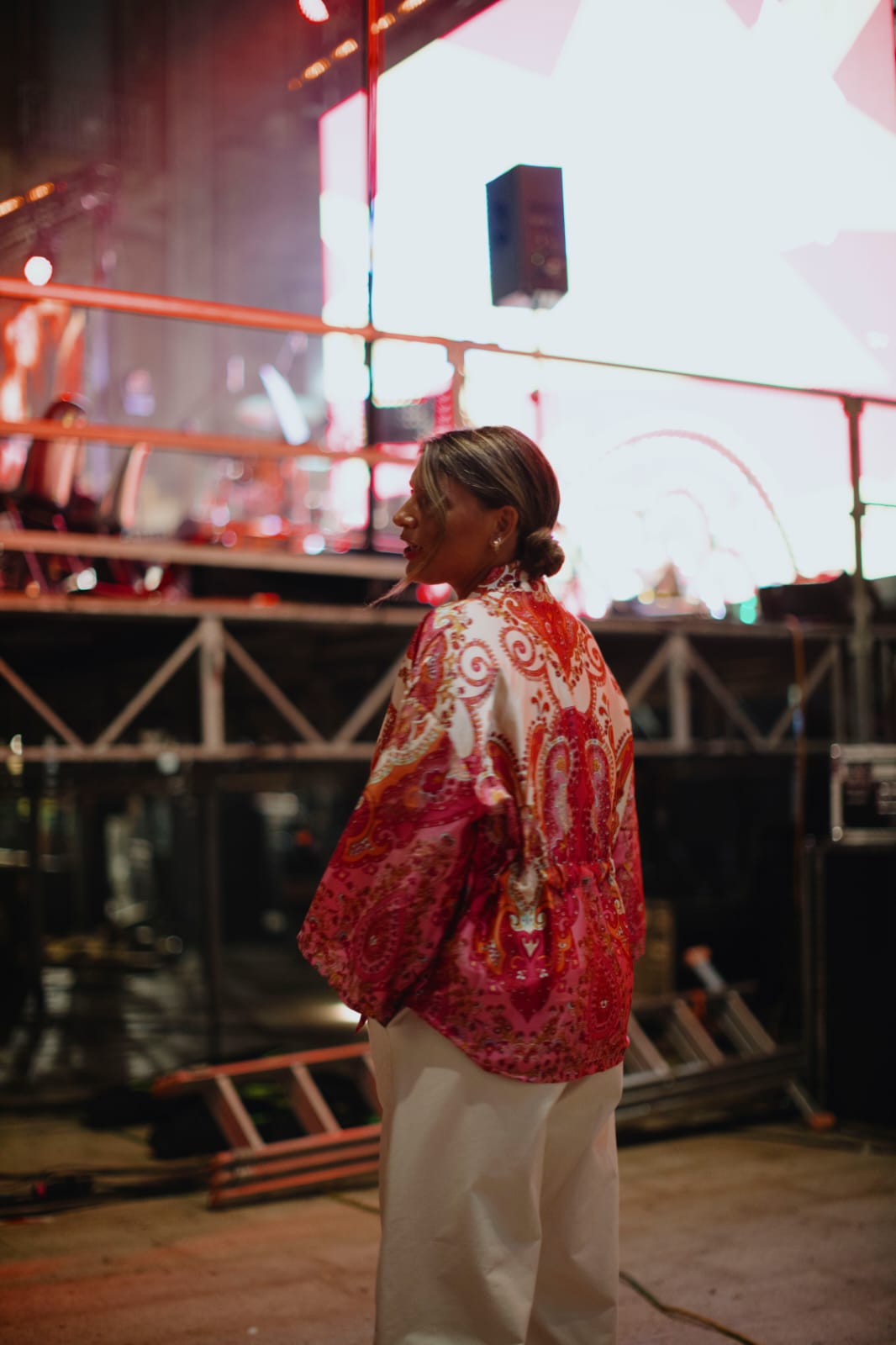Laura Rubino di profilo con jacket rosso, atmosfera serale luminosa